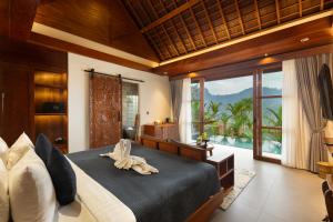 a bedroom with a large bed and a large window at Kankhara Villas Sidemen in Sidemen +96 photos
