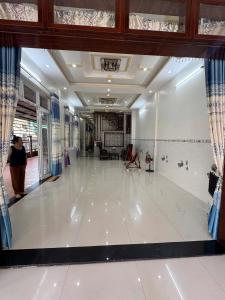 a large room with a white tile floor in a building at Phú Hiệp Hotel in Thanh Xuân