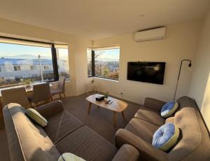 a living room with a couch and a tv at 110 Hampden Apartments in Hobart