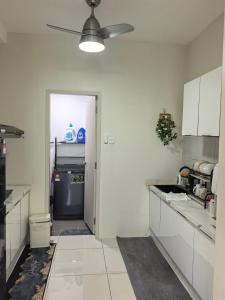 a kitchen with white cabinets and a black refrigerator at Batu Kawan Sunset Seaview Condo near Ikea & Design Village in Batu Kawan