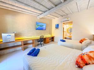 a bedroom with two beds and a desk in it at Tritonia Island Tintipán in Tolú +21 photos