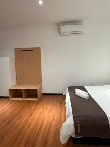 a bedroom with a bed and a wooden floor at The Velton Inn in Bintulu