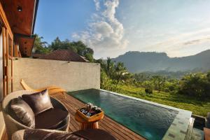 a balcony with a pool and a chair and a table at Kankhara Villas Sidemen in Sidemen