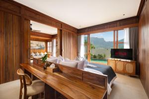 a bedroom with a bed and a desk and a television at Kankhara Villas Sidemen in Sidemen