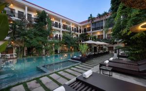 a hotel with a swimming pool in front of a building at Serenity Boutique in Siem Reap