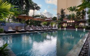 a pool with chairs and umbrellas in a hotel at Serenity Boutique in Siem Reap