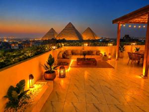 a patio with a couch and pyramids in the background at Tropitel Pyramids View Hotel in Cairo