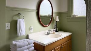 a bathroom with a sink and a mirror at Spacious 4 BDR Historic Home in Heart of Sioux Center in Sioux Center +50 photos