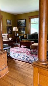 a living room with couches and a rug at Spacious 4 BDR Historic Home in Heart of Sioux Center in Sioux Center
