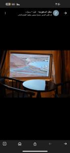 a computer screen with a table and a television at سما حقل للشقق المخدومه in Al Humaizah