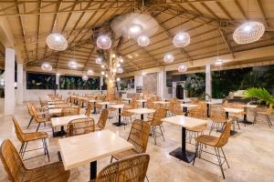 a restaurant with tables and chairs and lights at Cebu R Resort Tabuelan in Tabuelan