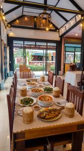 a long table with plates of food on it at Paradise resort, Don Det river view in Don Det
