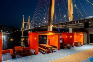 a bridge over a river with benches and a bridge at Yeosu Turtleship Pension in Yeosu +3 photos