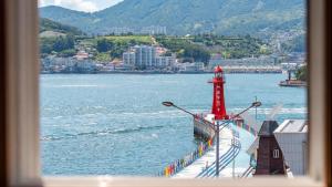 a red lighthouse on a boat in the water at Yeosu Turtleship Pension in Yeosu