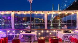 a balcony with two tables and a view of the city at Yeosu Turtleship Pension in Yeosu