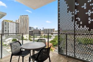 a patio with a table and chairs on a balcony at Direct Collective - Pavilion and Governor on Brookes in Brisbane
