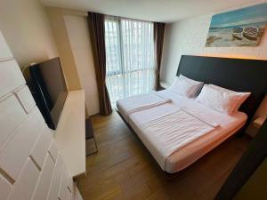 a bedroom with a bed and a tv in a room at BB House Khlong Tan บีบีเฮ้าส์ คลองตัน in Bangkok