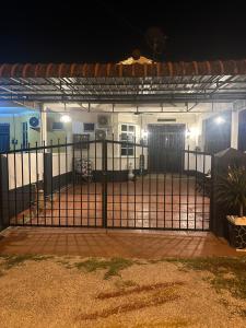 a gate in front of a house at night at Yueeda Homestay in Jertih