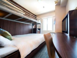 a bedroom with a bunk bed and a flat screen tv at Super Hotel Izumo Ekimae in Izumo