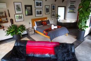 a bedroom with a bed and a couch and a tub at A Heavenly Escape in Halls Gap