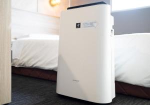 a white refrigerator sitting in a room next to a bed at Super Hotel Izumo Ekimae in Izumo +56 photos