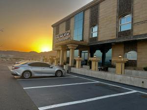 a car parked in a parking lot in front of a hotel at سما حقل للشقق المخدومه in Al Humaizah
