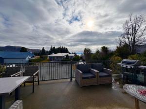 a patio with a couch and a table and a grill at The Bach in Lake Tekapo