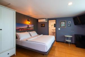 a bedroom with a large white bed and a table at BB House Phra Athit บีบี เฮ้าส์ พระอาทิตย์ in Bangkok
