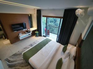 a bedroom with a large bed and a balcony at Ynad Mount Resort in Meppādi