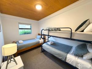 a room with two bunk beds and a table at The Bach in Lake Tekapo