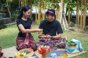 a man and a woman sitting on the grass at Premadhan Sanctuary in Canggu