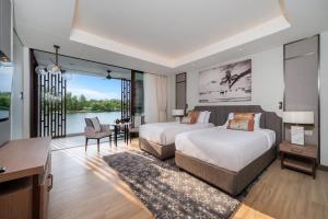 a hotel room with two beds and a desk and a living room at Laguna luxury apartment - Bang Tao - lake view in Bang Tao Beach +30 photos