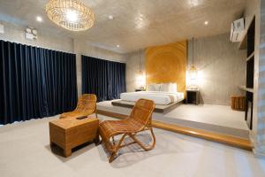 a bedroom with a bed and two chairs and a table at Cebu R Resort Tabuelan in Tabuelan +162 photos