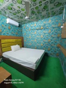 a bedroom with a bed in a room with a wall at Hotel The One Point, Uttara in Bāiljuri