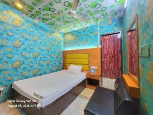 a bedroom with a bed in a room with a painted wall at Hotel The One Point, Uttara in Bāiljuri