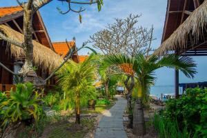 a path through a resort with palm trees and the ocean at Pemedal Beach Resort in Nusa Lembongan