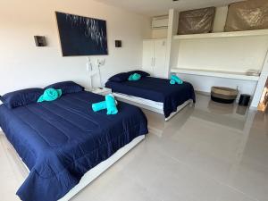 two beds in a room with blue comforters at Brisas Shores Beachfront connecting apartments, Cancun Hotel Zone in Cancún +39 photos