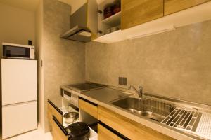 a small kitchen with a sink and a refrigerator at Olympic Inn Azabu in Tokyo
