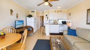 a living room with a couch and a table and a kitchen at Oceanfront 1BR • Updated Balcony • Cherry Grove • Sea Cabin 206-A in Myrtle Beach