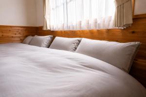a white bed with four pillows in a bedroom at BLUEBAY TERRACE okutama in Okutama