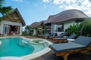 a villa with a swimming pool and a house at Bamboo Layang Ubud in Ubud