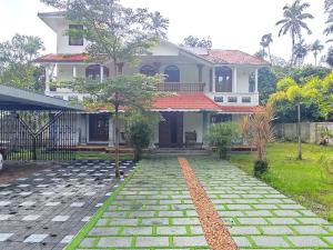 a house with a walkway in front of it at Casa de Victoria in Alleppey +5 photos