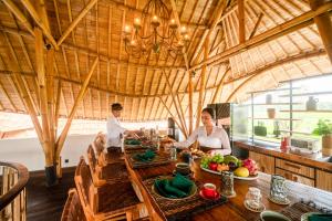 a man and woman sitting at a table in a restaurant at Bamboo Layang Ubud in Ubud