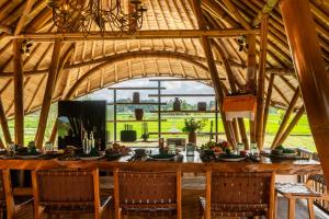 a dining room with a large wooden table and chairs at Bamboo Layang Ubud in Ubud