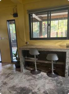 two stools at a bar in a room with a mirror at One bedroom apartment Hin Kong in Ko Phangan