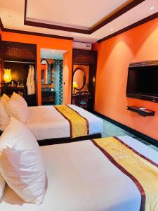 a hotel room with two beds and a flat screen tv at Spatel d'Annam - Imperial Boutique Spa & Hotel in Hue