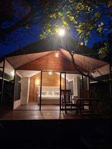 a house with a table and chairs on a deck at night at Wilpattu Wilderness Camping in Wilpattu