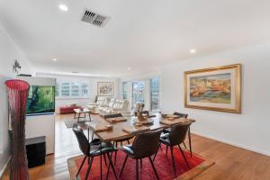 a dining room and living room with a table and chairs at Blue Summer House in Long Jetty