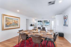 a dining room with a wooden table and chairs at Blue Summer House in Long Jetty