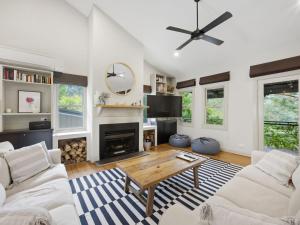 a living room with white furniture and a fireplace at Woodbine Lodge in Marysville